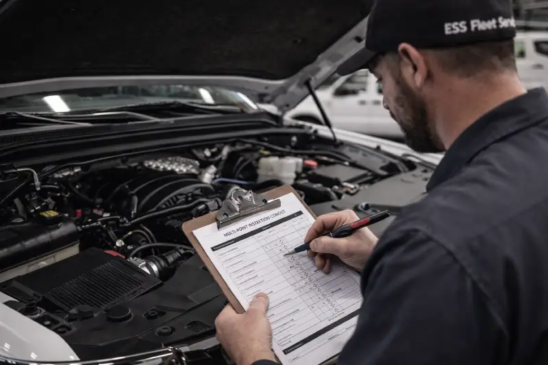 Fleet technician inspecting vehicle engine